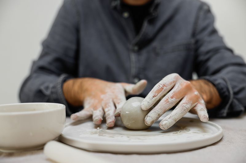 Potter working on a wheel throwing a vase