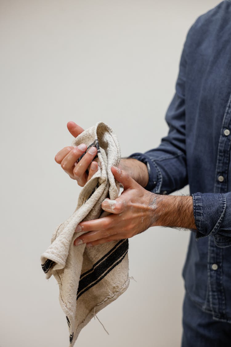 Close-up Photo Of Person Cleaning His Hands With A Towel 