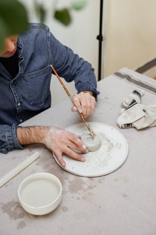 Man Molding Clay with Paintbrush