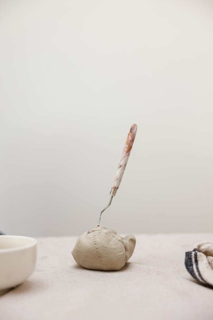 A Ball Of Clay With A Spatula Stuck In It 