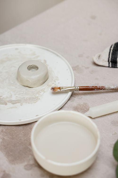 Free Close-up of clay crafting tools and materials on a minimalist canvas backdrop. Stock Photo