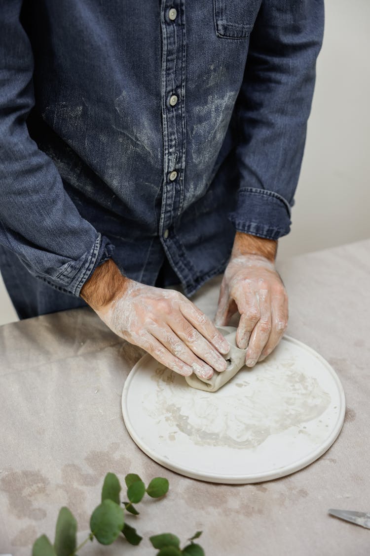 Person Molding Clay With Bare Hands