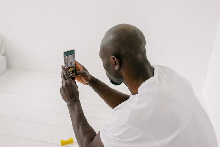 Bald African American Man Taking Photo With Mobile Phone