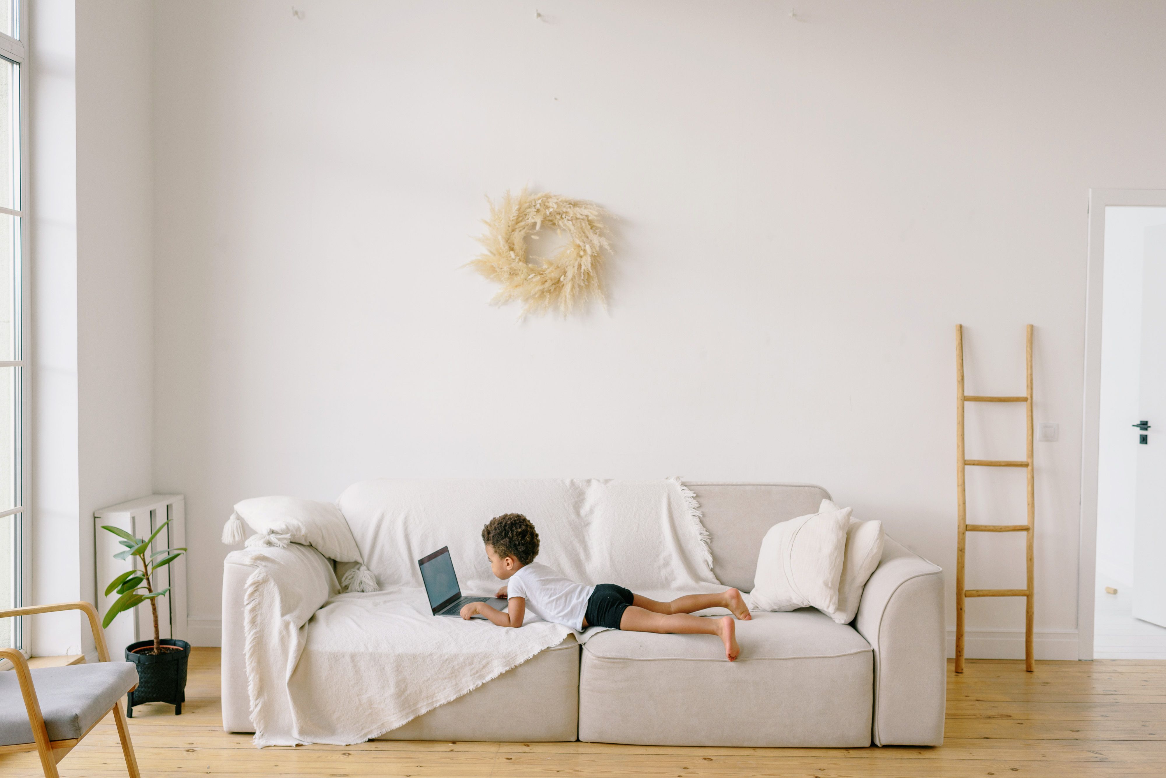 Little Boy Laying on Sofa while Using a Laptop · Free Stock Photo