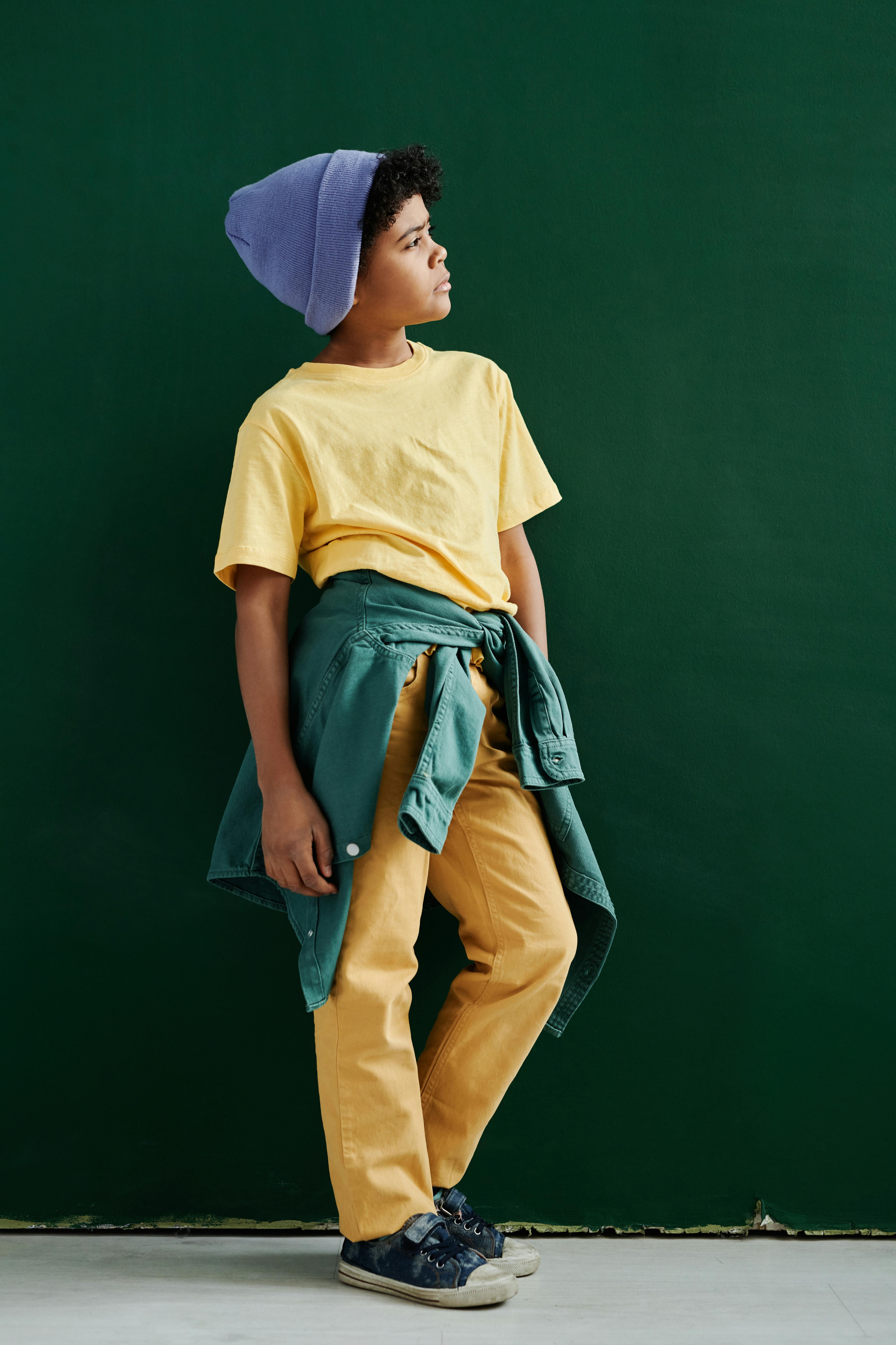 boy in yellow shirt posing on green background