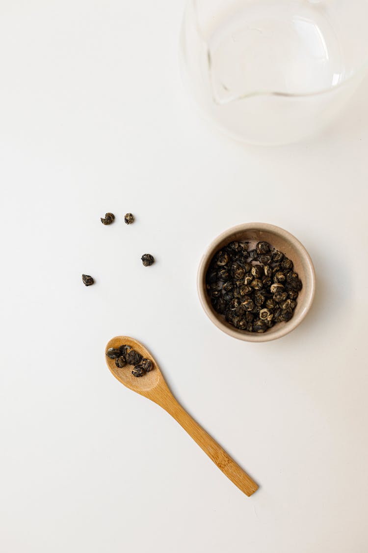 Bowl Of Black Beans Near Brown Wooden Spoon