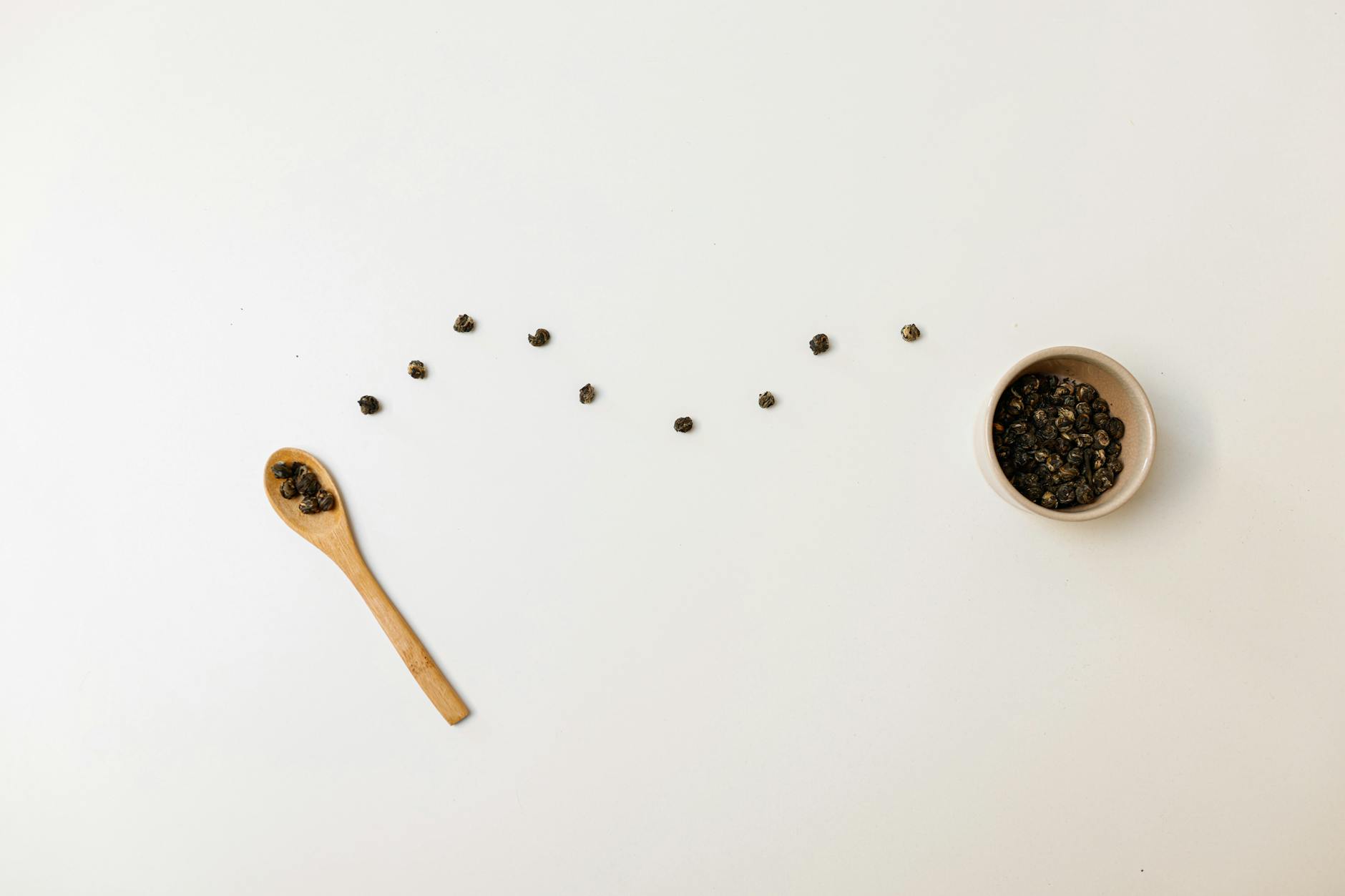 Black Peppercorns On A Wooden Surface