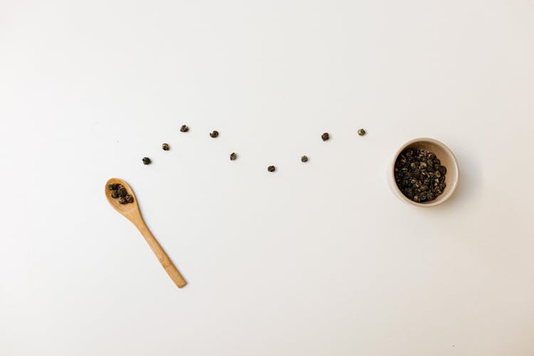 Tableware And White Surface With Black Beans