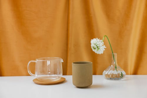 Ceramic Cup, Glass Pot and a Flower in a Glass Vase 