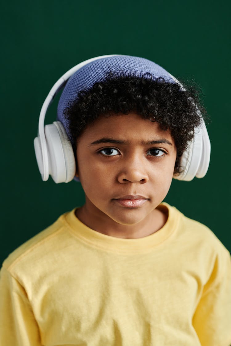 A Boy In Yellow Shirt While Wearing Headphones