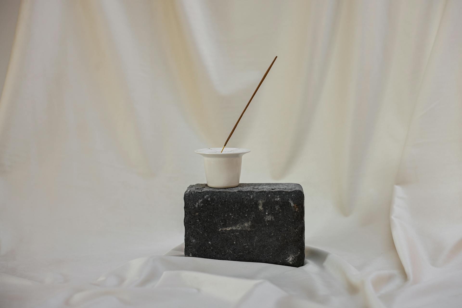 Small Container with Stick on Gray Rock