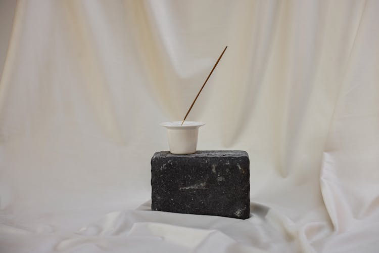 Small Container With Stick On Gray Rock