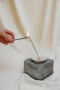 Person Holding Lighted Candle on White Candle Holder