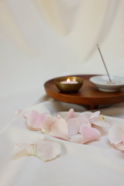 Free Selective Focus Photo of Pink Petals Near a Lit Candle Stock Photo
