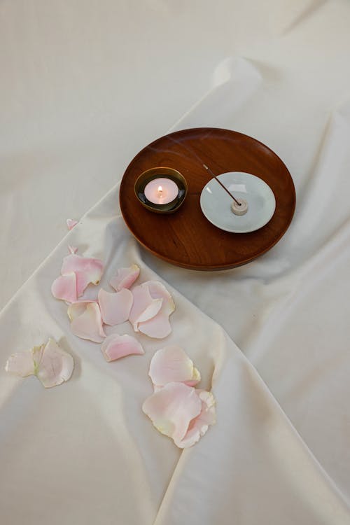 Photo of a Lit Candle Beside an Incense