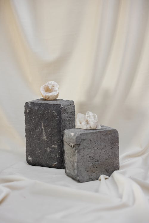 Still Life with White Minerals on Gray Concrete Cubes and Fluid Fabric