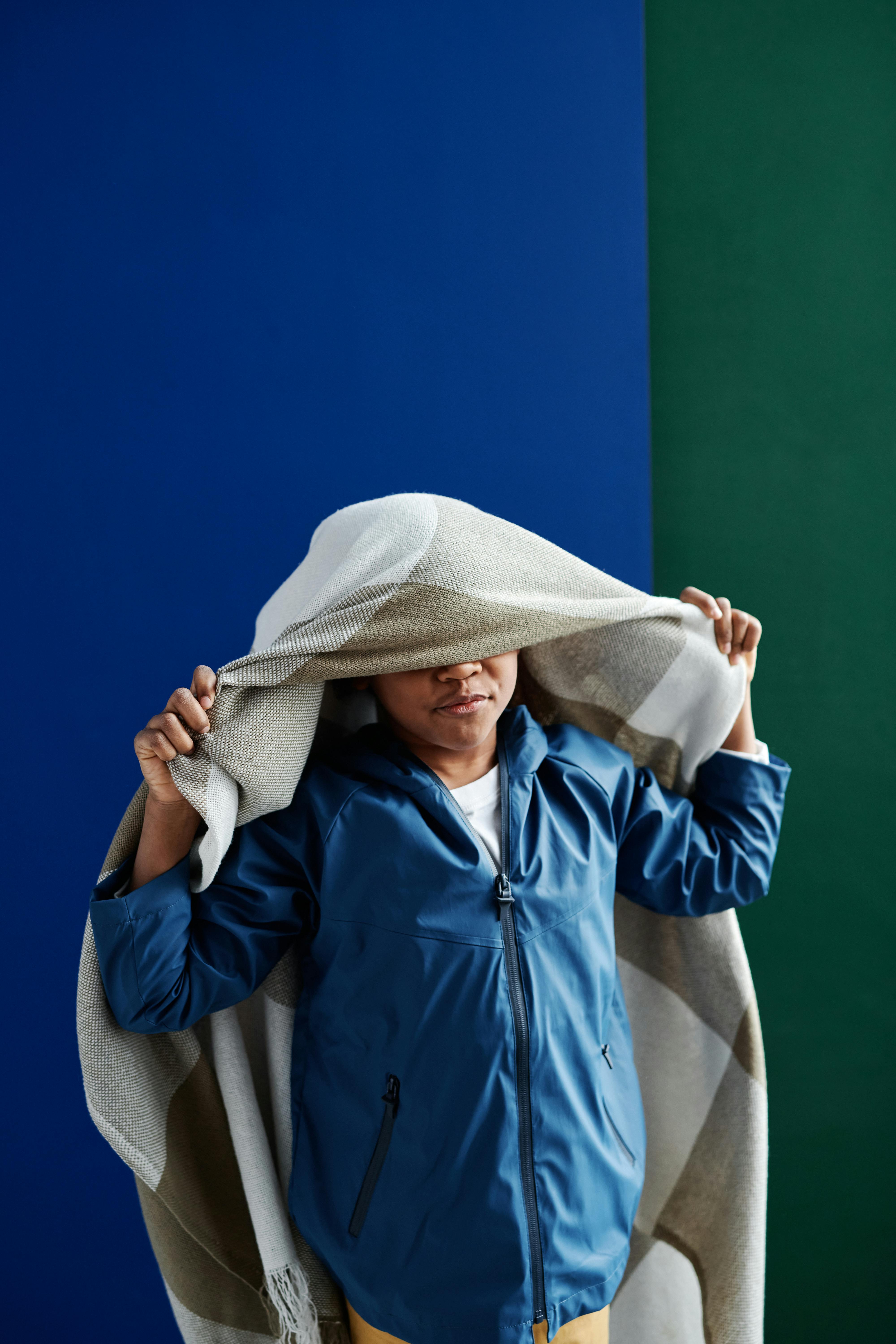 A Person Wearing Blue Jacket with a Blanket Over Head Free Stock Photo