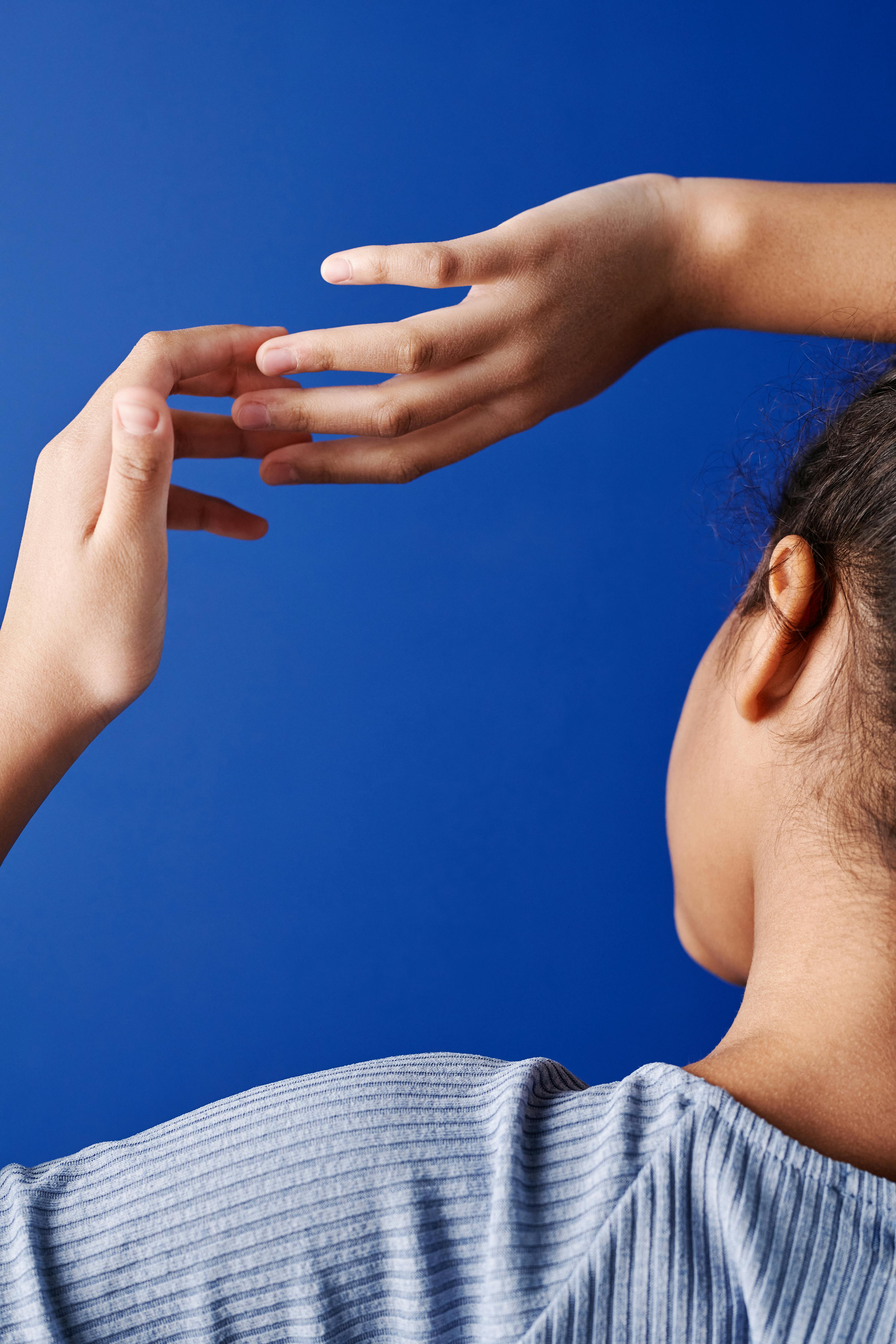 Elegant composition of hands with graceful curves against a vivid blue background.