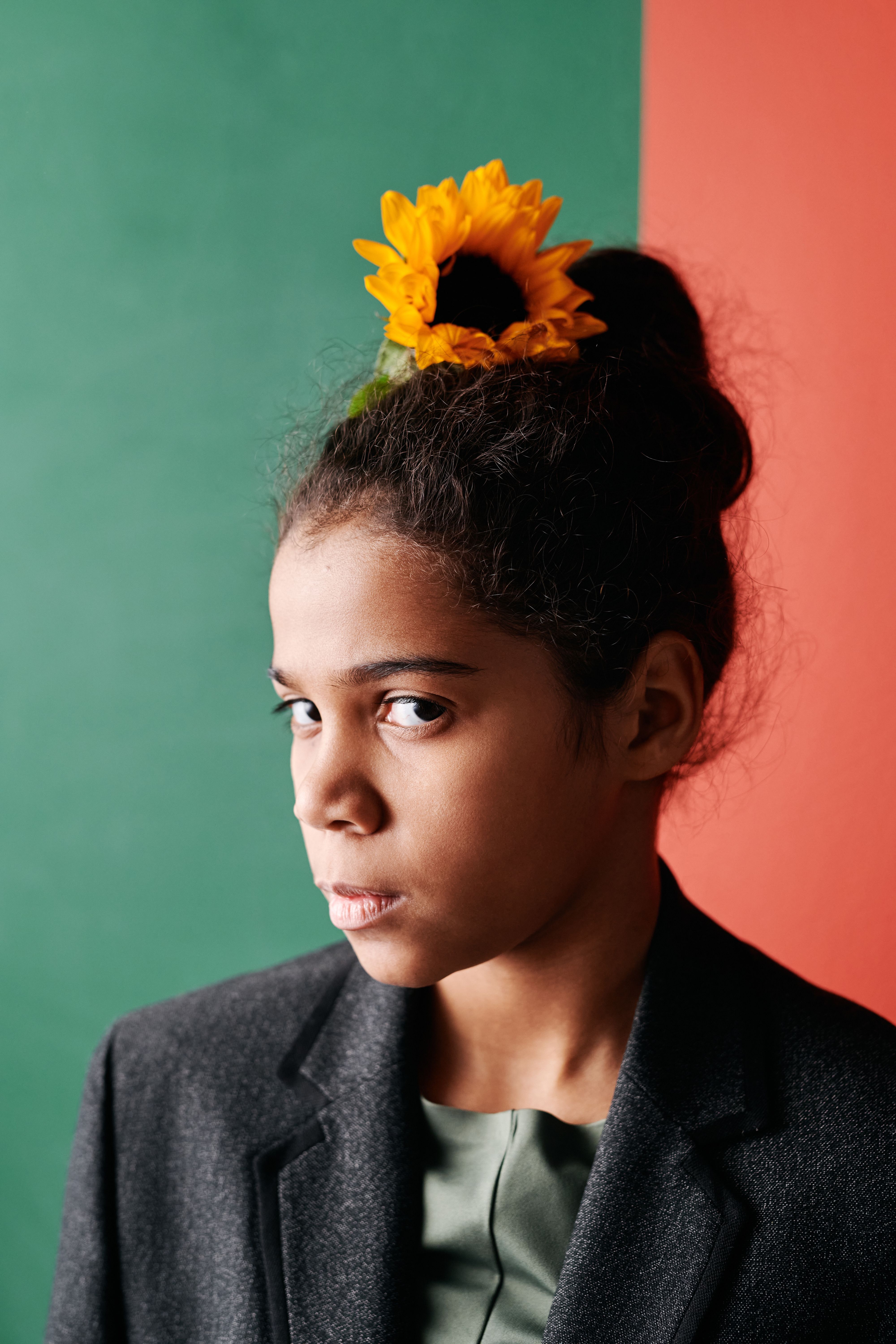 A Woman in Serious Face with Sunflower on Her Hair · Free Stock Photo