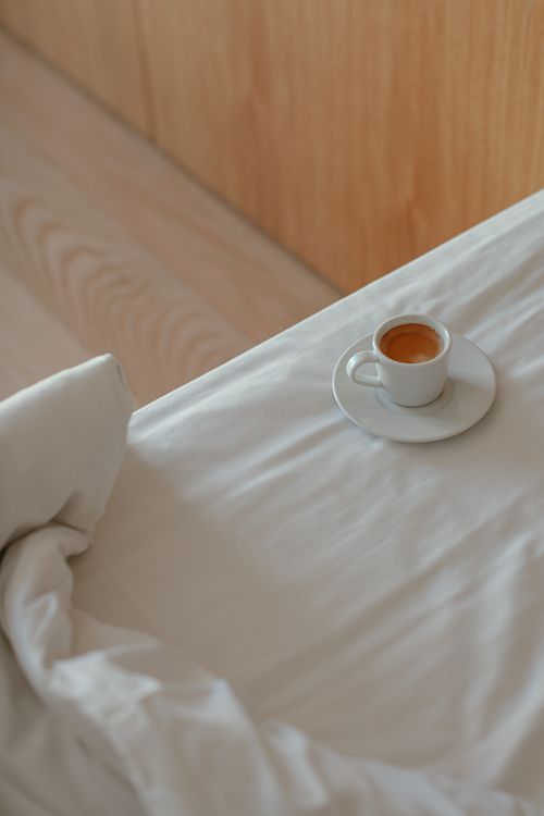 Free A ceramic cup of espresso on a white linen with a soft wooden background. Stock Photo