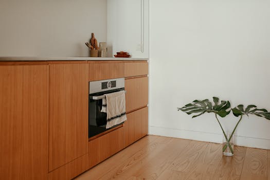 A sophisticated minimalist kitchen featuring wooden cabinets and sleek design elements.