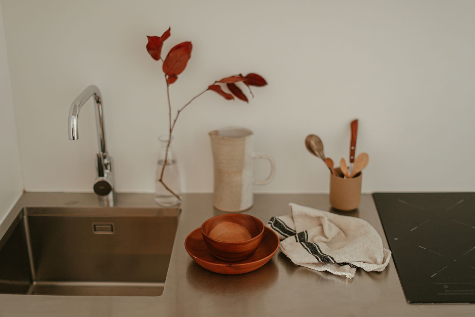 Modern kitchen design featuring stainless steel sink and minimalist decor.