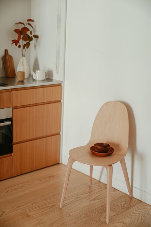 Free Minimalist kitchen corner with wooden chair and decor items, showcasing simple and modern design. Stock Photo