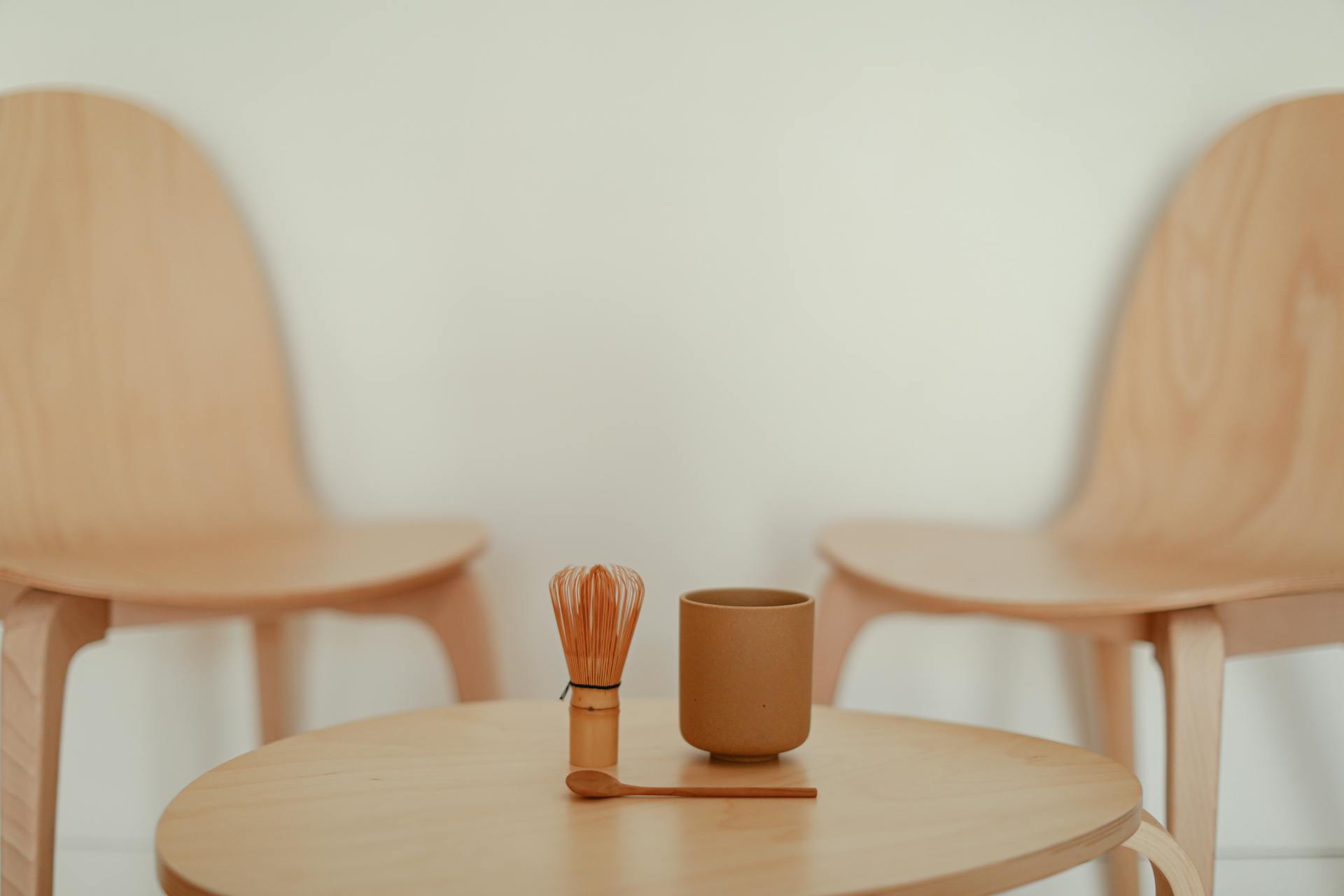 A Cup and a Whisk on a Table