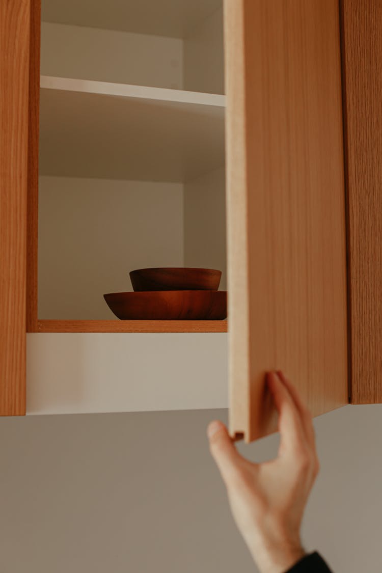 Person Opening A Cabinet