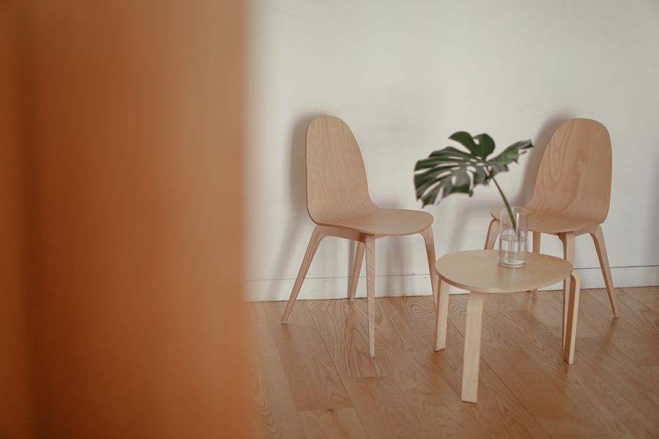 A Perfect Folding Chair for Compact Spaces: 5 Principles of Japanese Minimalist Design Minimalist Japanese folding chair on natural wood tones background