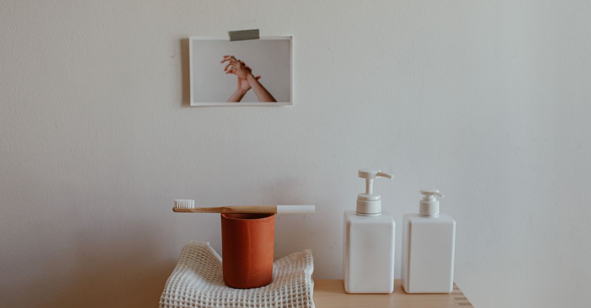 minimalist bathroom counter with only a toothbrush and soap dispenser