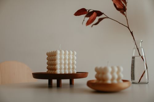Free Elegant minimalist still life featuring sculptural candles and vase with branches. Stock Photo