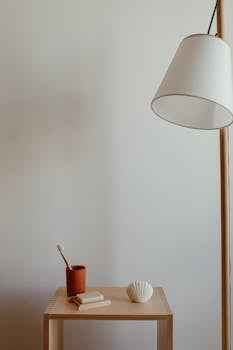 Stylish minimalist interior featuring a wooden table, modern lamp, and decor.