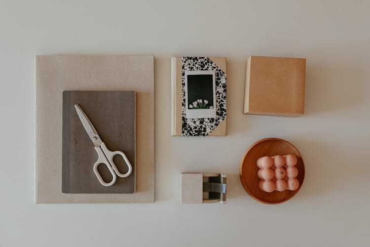 White And Silver Scissor On Brown Notebook