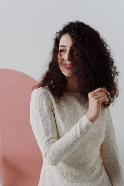 Woman Wearing White Long Sleeve Dress with Curly Hair