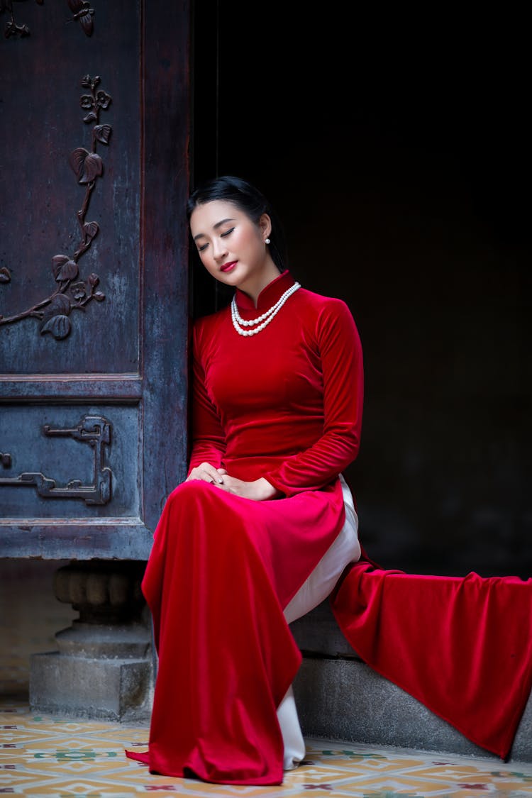 Elegant Relaxed Asian Woman Sitting At Doorway With Closed Eyes