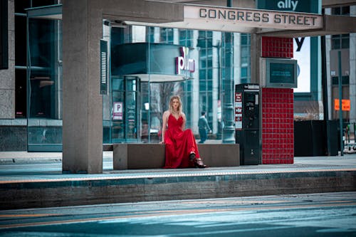 Photo of a Woman at a Bus Stop Looking at the Camera