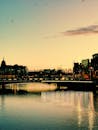 日落时分，都柏林海滨与城市风光的宁静景致，倒映在平静河面上，映照着充满活力的光芒