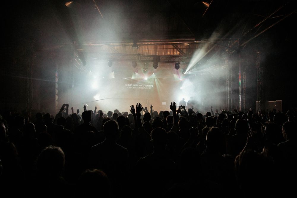 A crowd lit by stage lights at a late show — photo by Danik Prihodko on Pexels