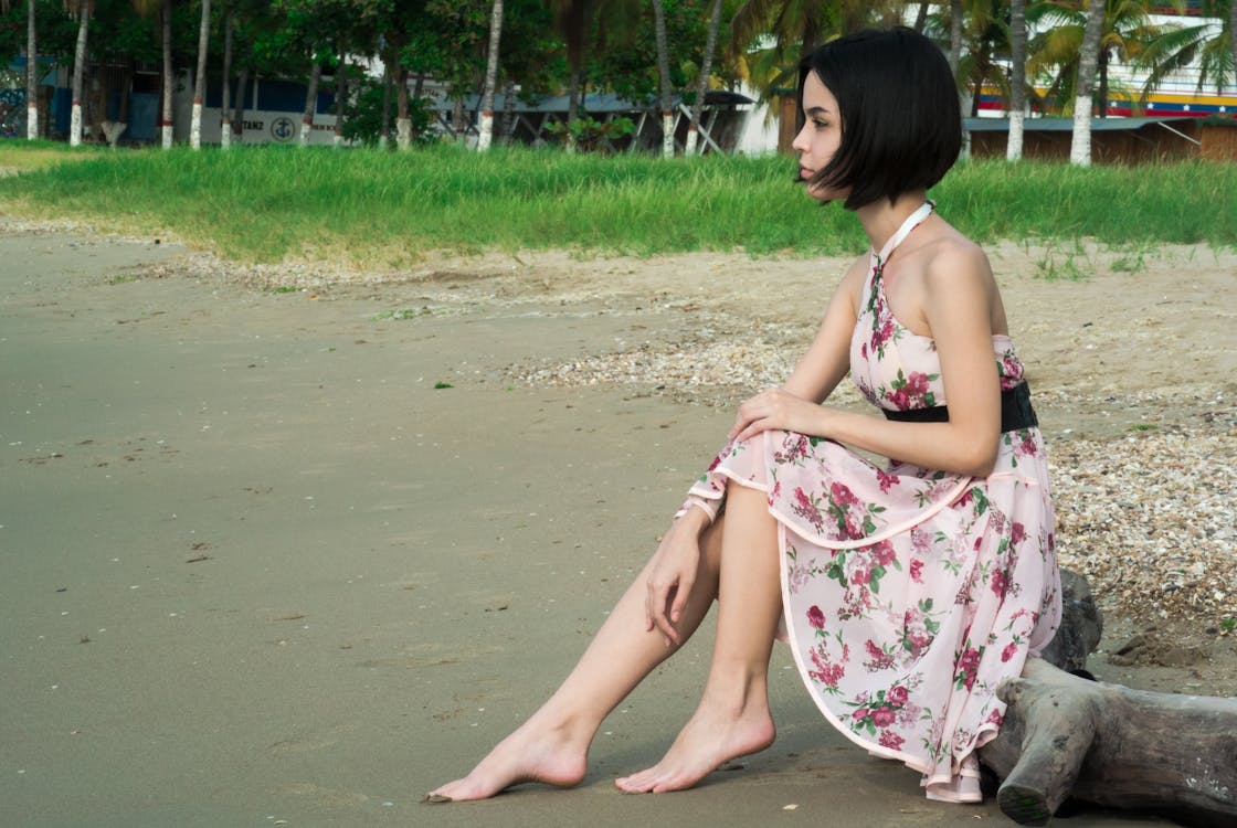 Woman in Pink Floral Halter Dress Seating in Driftwood