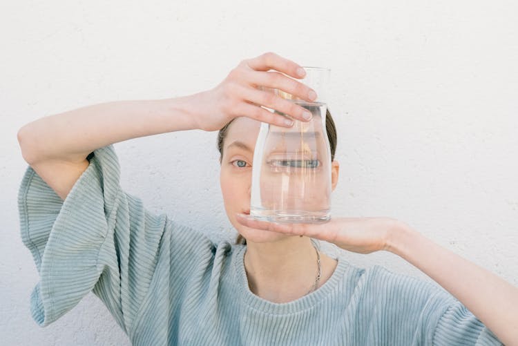 A Woman Holding A Glass Of Water