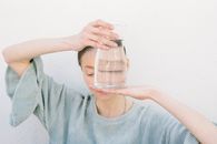 Woman in Blue Crew Neck Shirt Holding Clear Glass Jar
