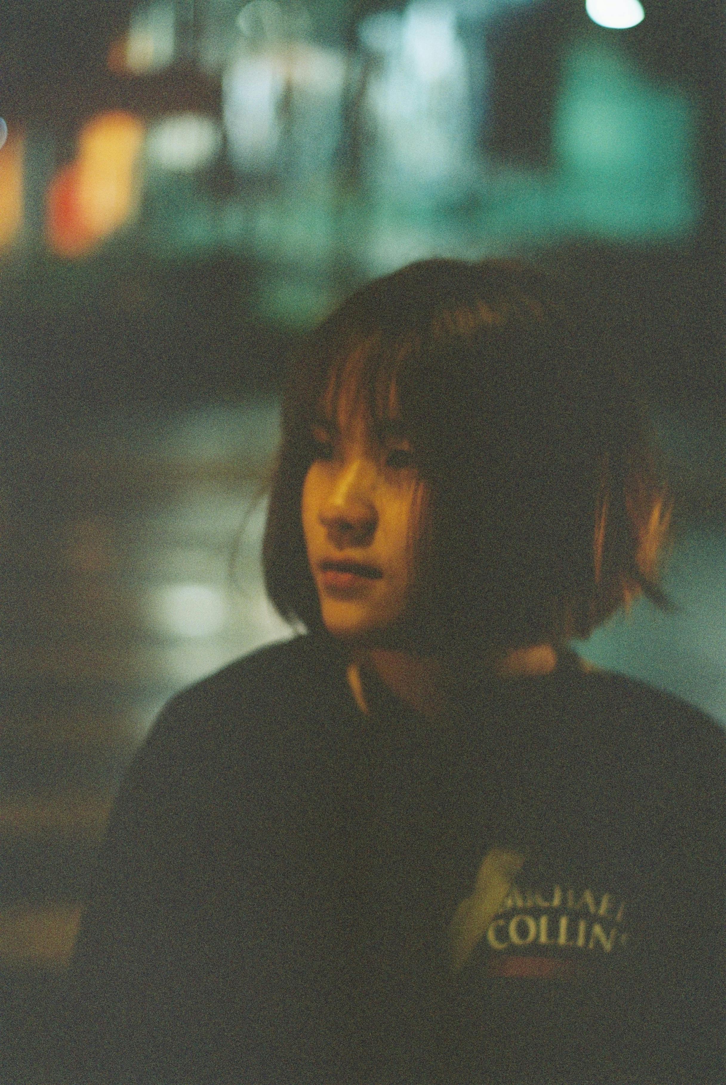 Artistic film photo of a woman with short hair, taken at night with moody lighting.