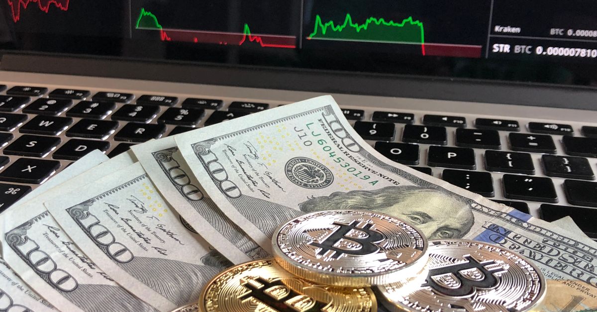 Ilustrasi koin Bitcoin berdampingan dengan uang dolar AS yang menggambarkan kaitan kebijakan The Fed dengan harga kripto