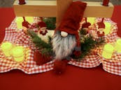 舒适的圣诞餐桌上摆放着蜡烛和圣诞老人侏儒，营造出温暖的节日氛围