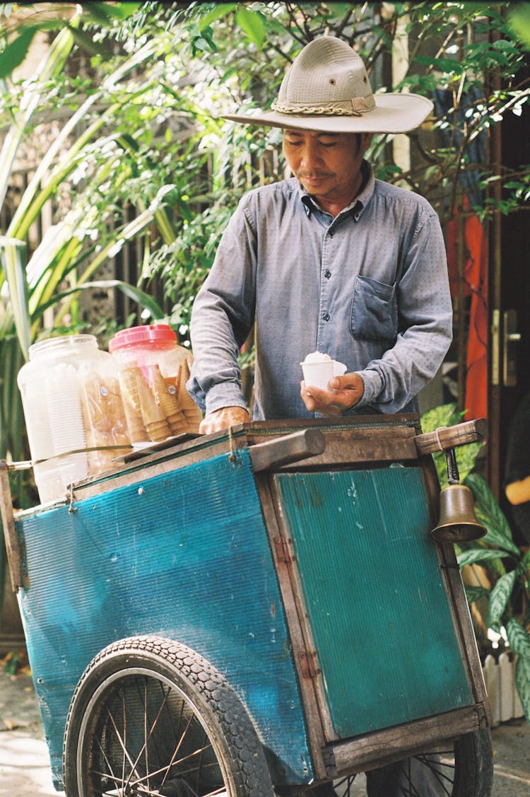 Photo Of A Man With A Beige Hat Selling Ice Cream