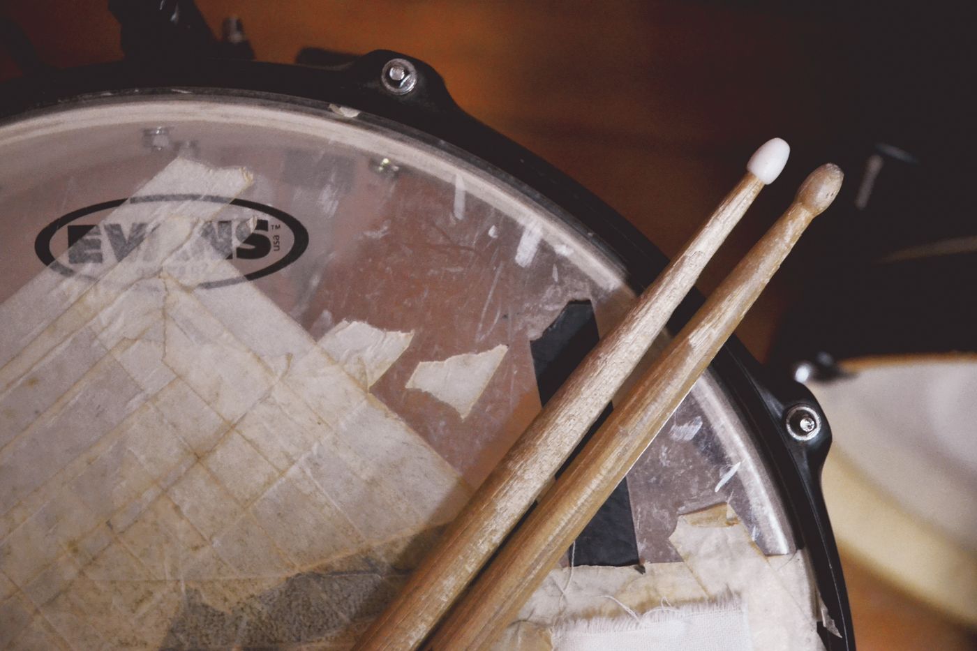 Drumsticks resting on a snare drum head