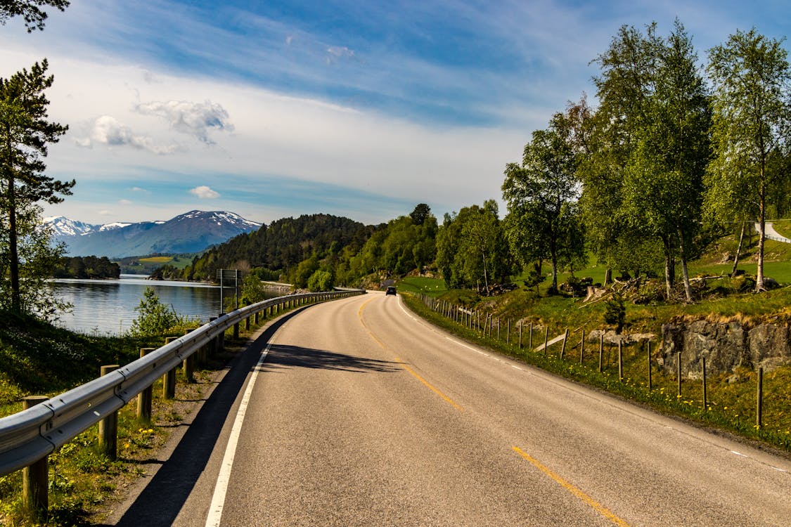 Free Brown Asphalt Road Beside Lake Stock Photo