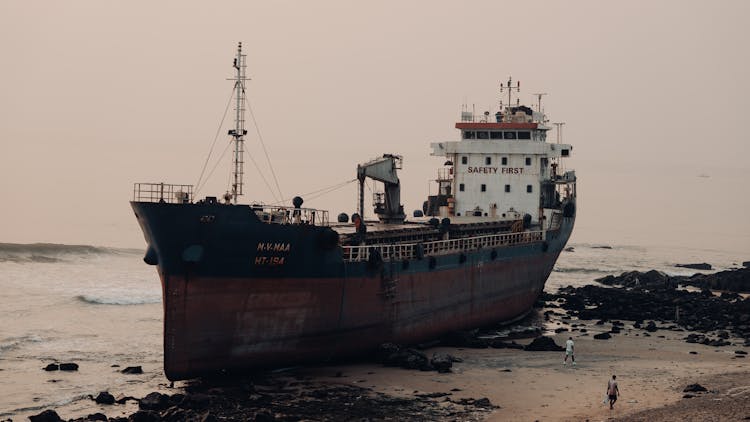 An Old Cargo Ship Docked On The Shore