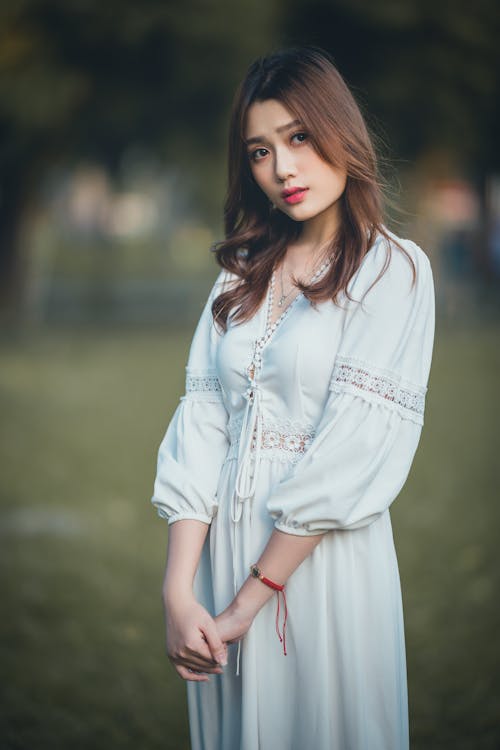 Stylish ethnic female teenager standing on field in nature